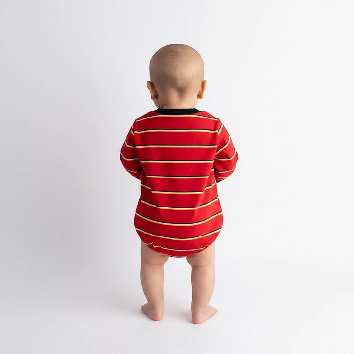 Back view of a baby wearing a Sea Dragon Dreams red striped long-sleeve bubble romper with black trim