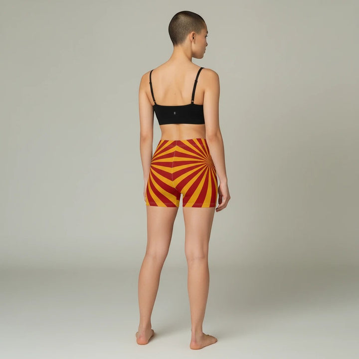 Sea Dragon Dreams women's skinny fit shorts in red and yellow sunburst pattern, worn by a model from the back view.