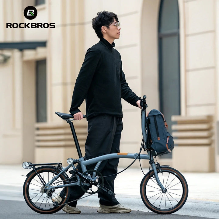 Sea Dragon Dreams ROCKBROS blue vintage folding bike backpack mounted on a grey folding bicycle held by a man.