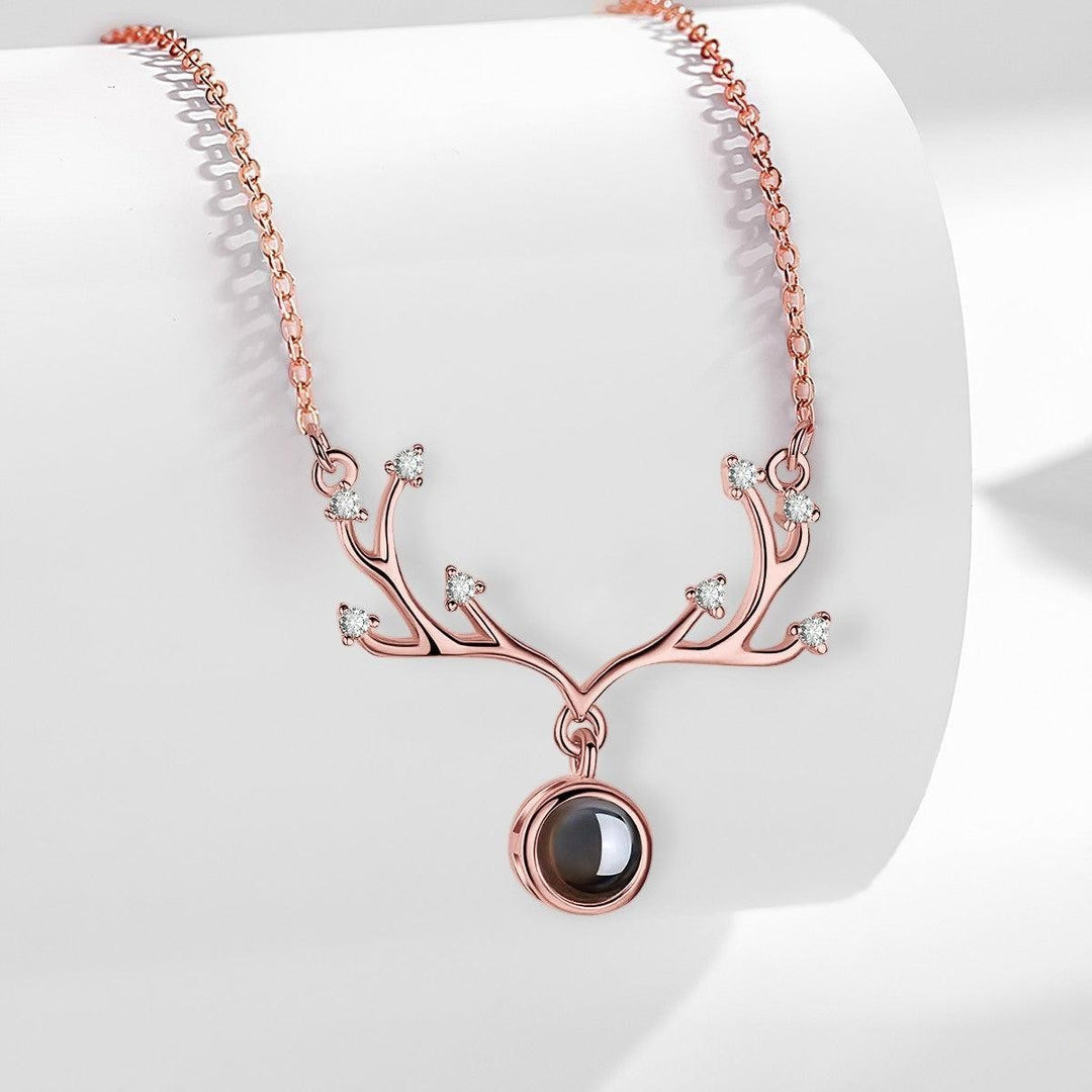 Sea Dragon Dreams rose gold antler projection necklace with a circular pendant and delicate crystal accents.