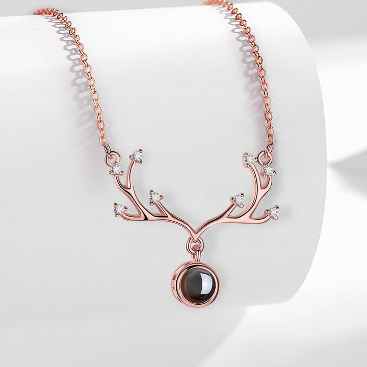 Sea Dragon Dreams rose gold antler projection necklace with a circular pendant and delicate crystal accents.