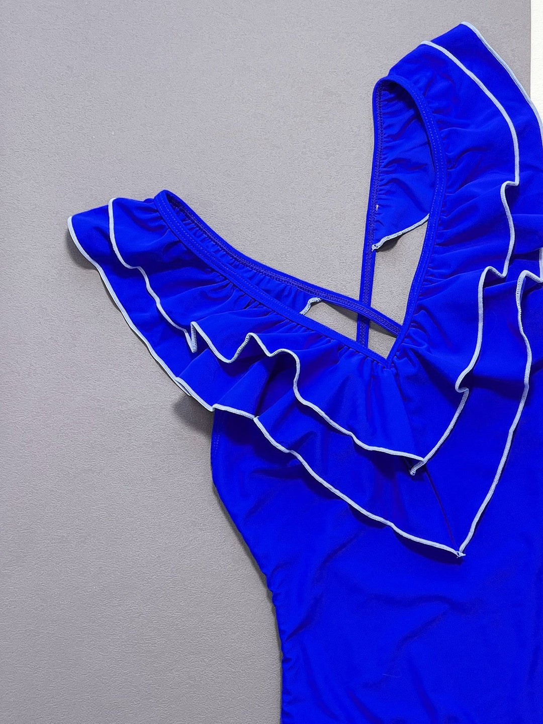 Sea Dragon Dreams royal blue one-piece swimsuit with ruffled V-neckline and white trim detail