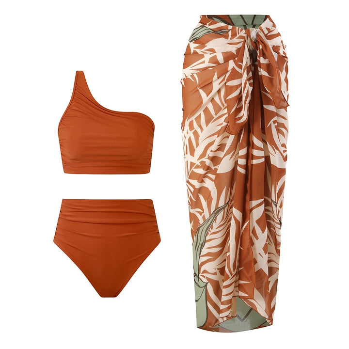 Sea Dragon Dreams rust orange one-shoulder bikini set with high-waisted bottoms and a matching tropical print sarong.