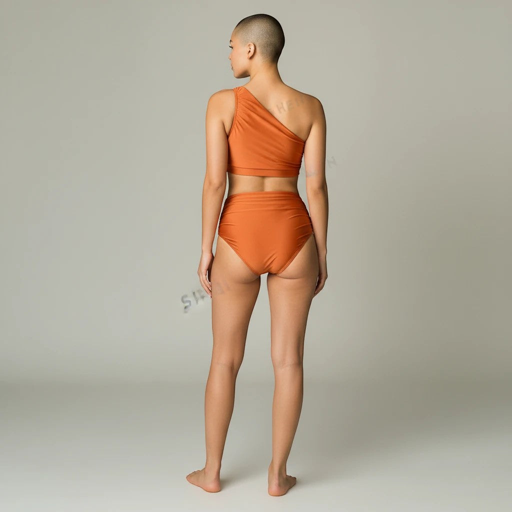 Sea Dragon Dreams rust orange one-shoulder bikini set with high-waisted bottoms on a model, back view.
