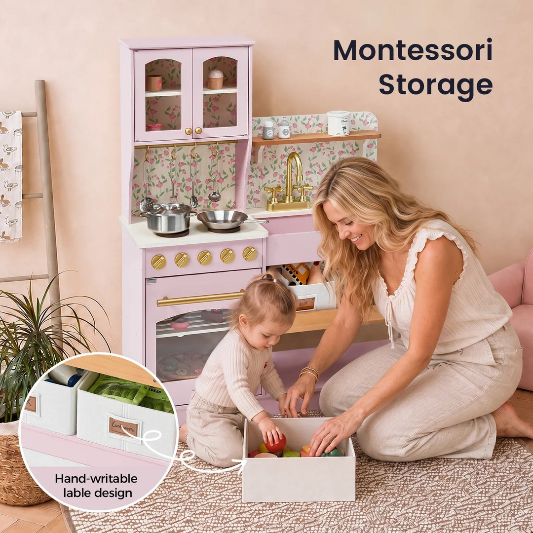 Sea Dragon Dreams Tiny Land wooden play kitchen in Sakura Pink with floral backsplash, storage bins, and toy cookware.