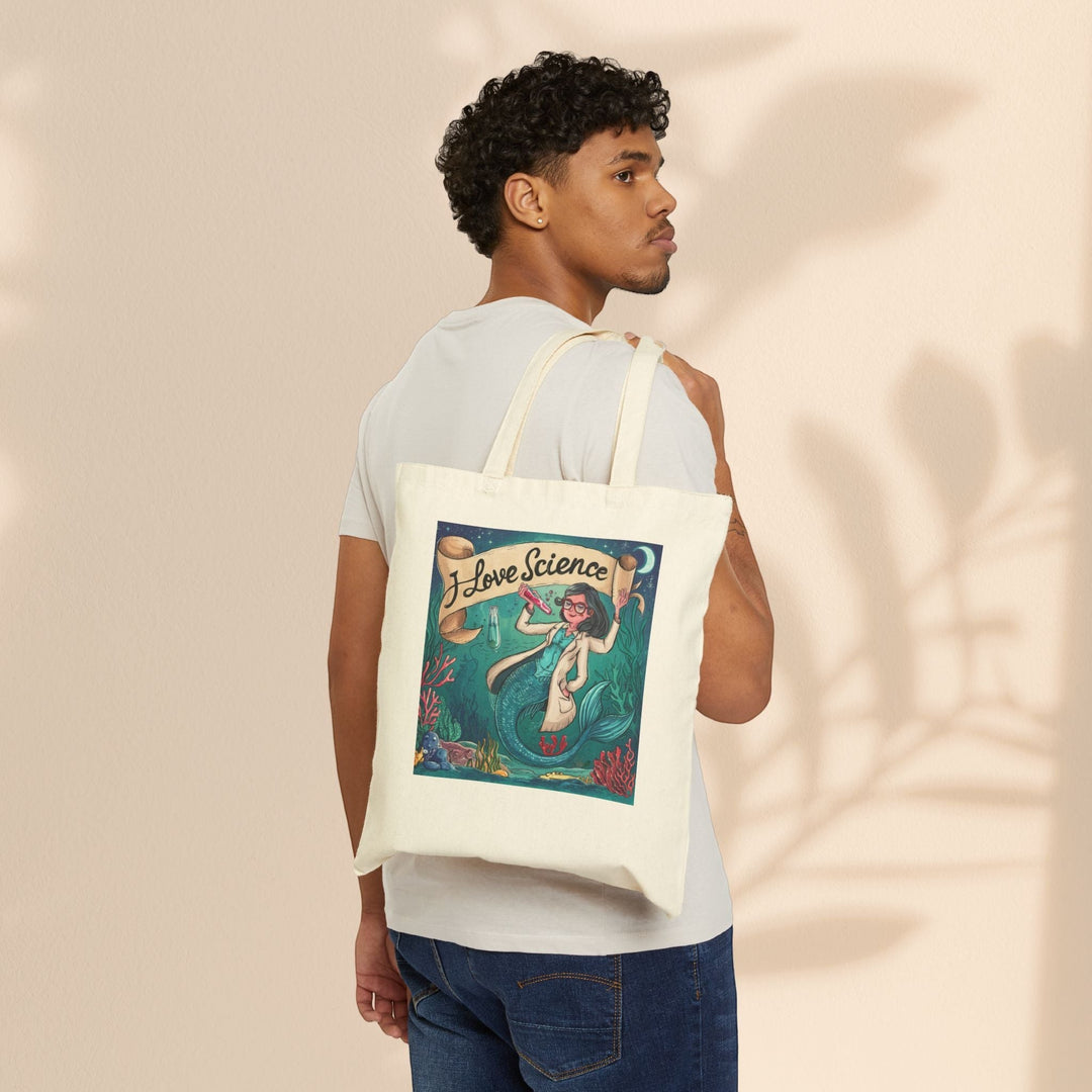 Sea Dragon Dreams cotton canvas tote bag with I Love Science mermaid illustration worn over shoulder by a man