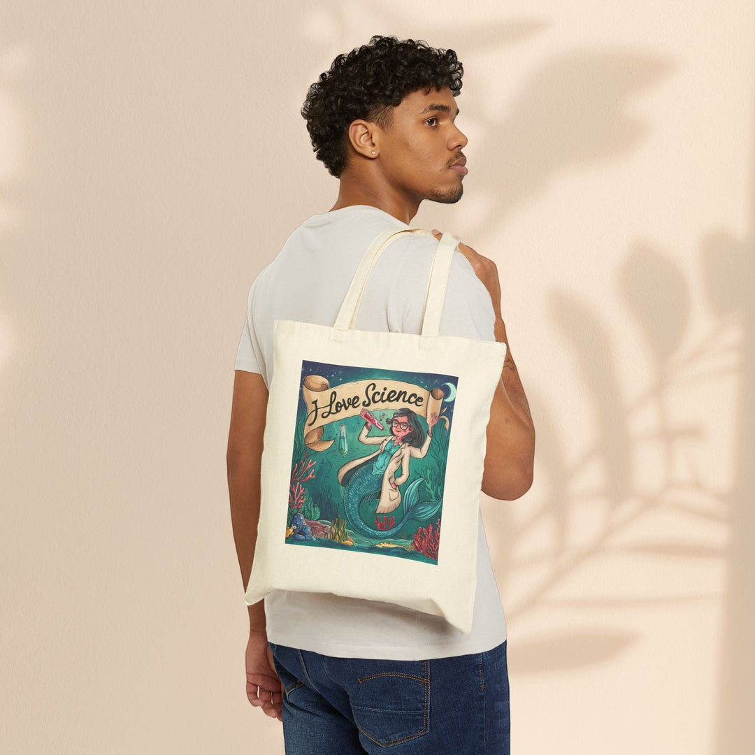 Sea Dragon Dreams cotton canvas tote bag with I Love Science mermaid illustration worn over shoulder by a man