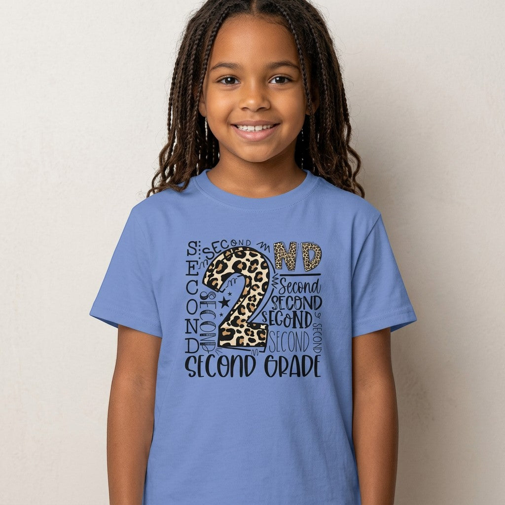A young girl wearing a Sea Dragon Dreams blue cotton t-shirt with a leopard print Second Grade graphic design.