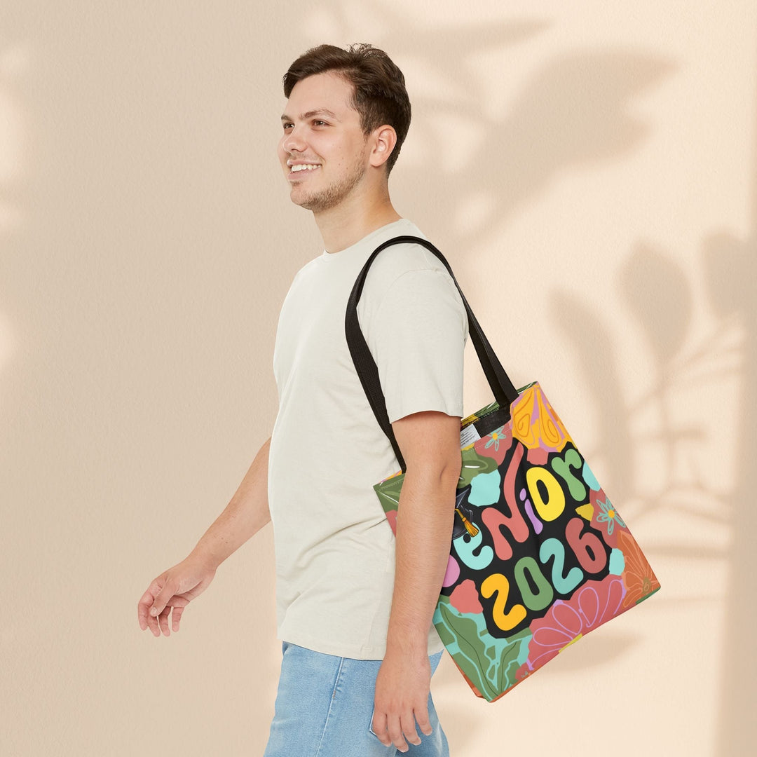 Sea Dragon Dreams Senior 2026 tote bag with colorful floral design carried over the shoulder by a young man.