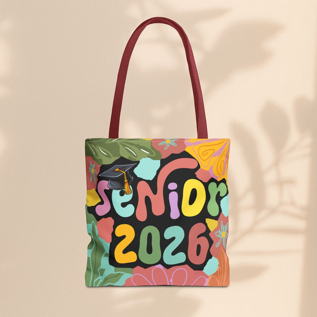 Sea Dragon Dreams Senior 2026 tote bag with colorful floral design, graduation cap graphic, and maroon handles.