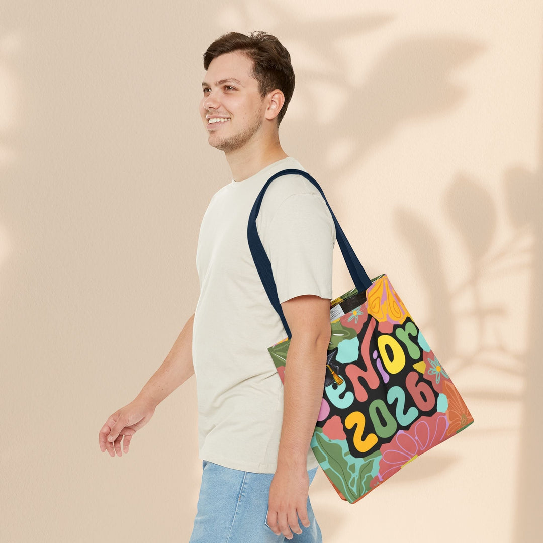 Sea Dragon Dreams Senior 2026 tote bag with colorful floral design carried over the shoulder by a smiling man
