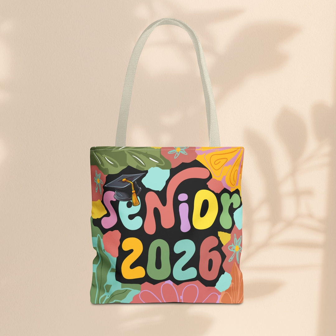 Sea Dragon Dreams Senior 2026 tote bag with colorful floral patterns and a graduation cap on a beige background.