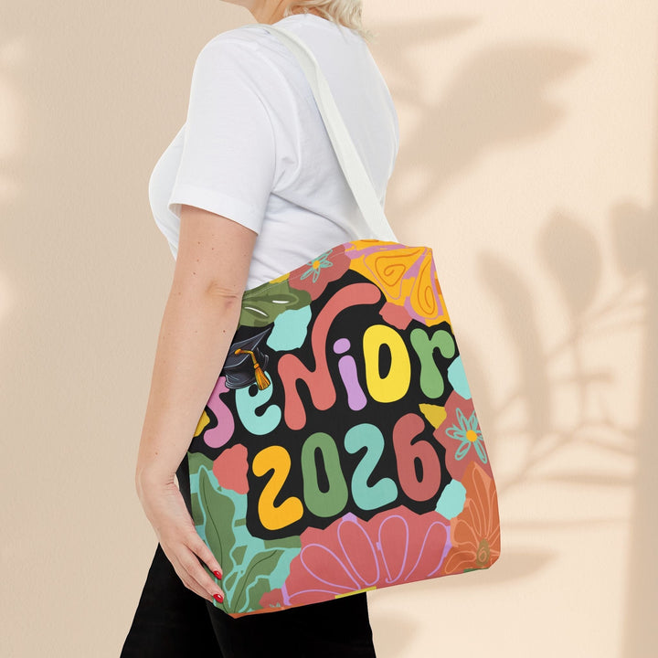 Sea Dragon Dreams Senior 2026 tote bag with colorful floral print and graduation cap icon on a woman's shoulder