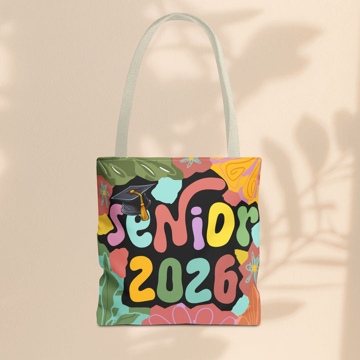 Sea Dragon Dreams Senior 2026 tote bag with colorful floral patterns and a graduation cap on a black background.