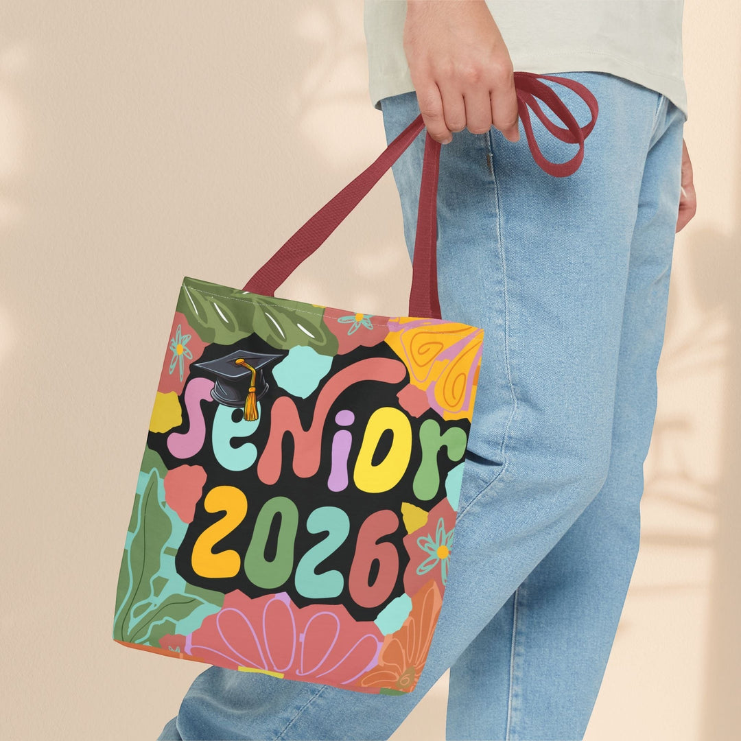Sea Dragon Dreams Senior 2026 tote bag with colorful floral print and graduation cap graphic held by a person.