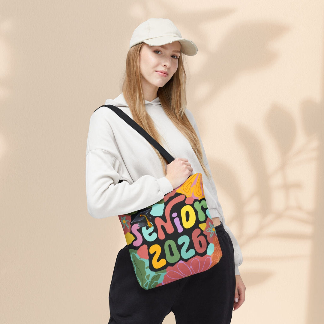 Sea Dragon Dreams Senior 2026 tote bag with colorful graphic print carried by a woman wearing a beige cap and hoodie.