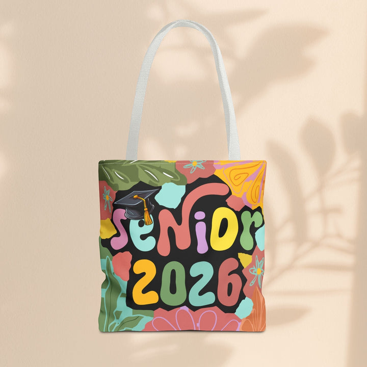 Sea Dragon Dreams Senior 2026 tote bag with colorful floral patterns and a graduation cap on a beige background.