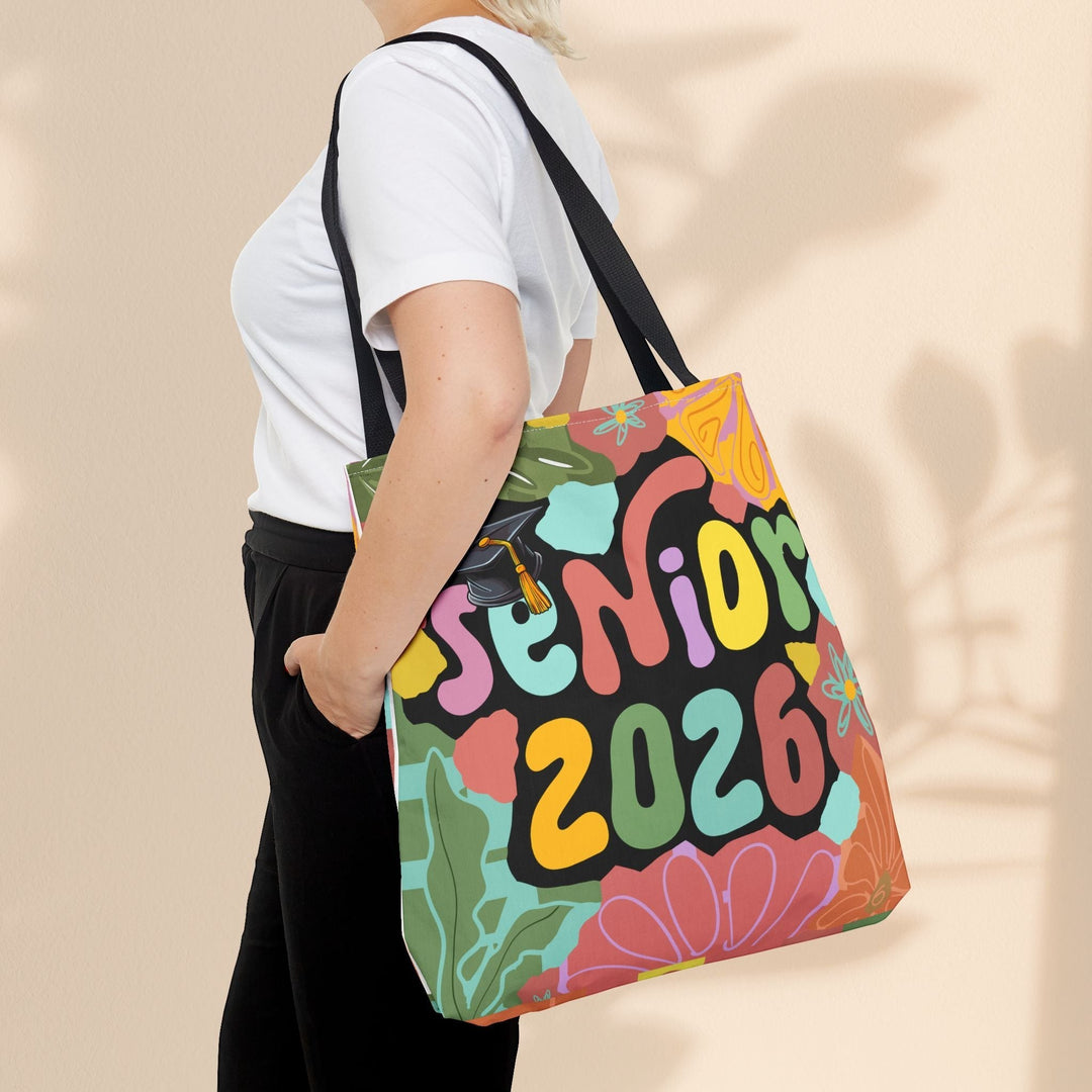 Sea Dragon Dreams Senior 2026 tote bag with colorful floral design and graduation cap, worn over the shoulder.