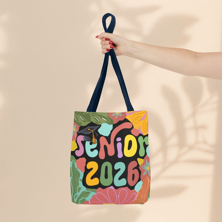 Sea Dragon Dreams Senior 2026 tote bag with colorful floral pattern, graduation cap, and navy blue handles.