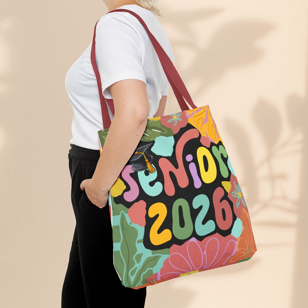 Sea Dragon Dreams Senior 2026 tote bag with colorful floral print and graduation cap, worn over the shoulder.