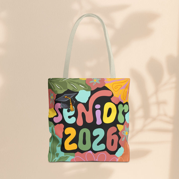 Sea Dragon Dreams Senior 2026 tote bag with colorful floral patterns and a graduation cap on a beige background.