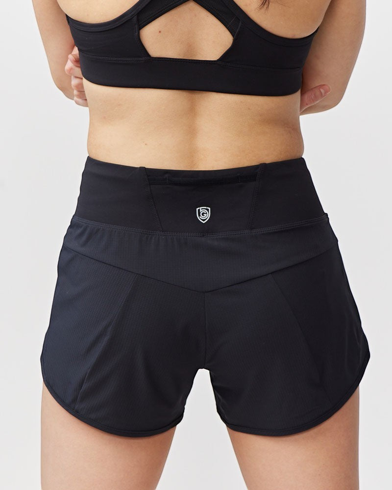 Back view of Sea Dragon Dreams Sheva high rise black running shorts with a wide waistband and zip pocket.