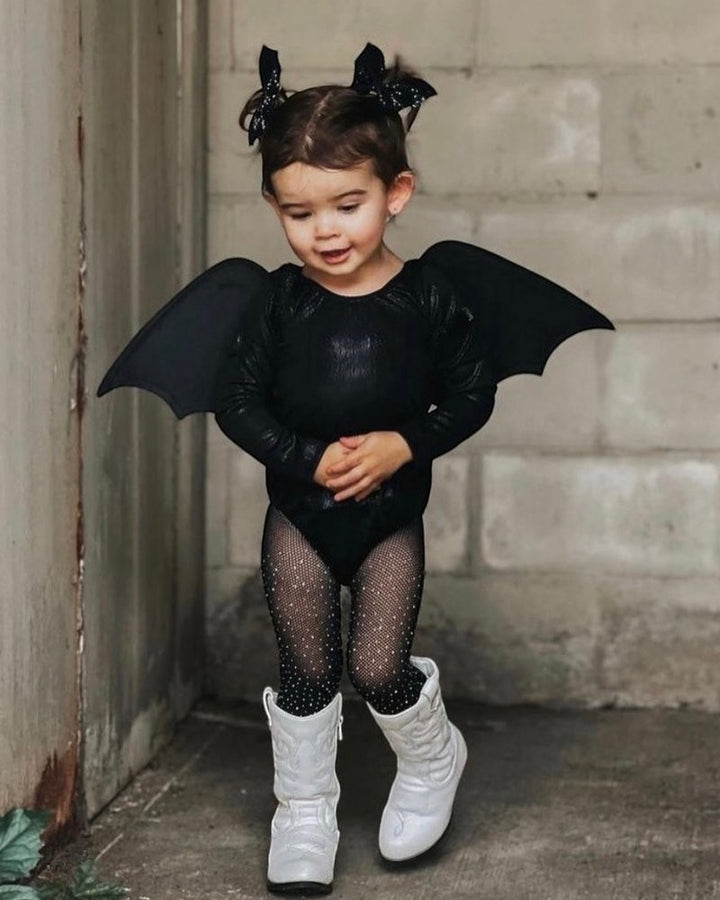 Toddler girl wearing a Sea Dragon Dreams shimmering black long sleeve leotard as a bat costume with wings and tights.