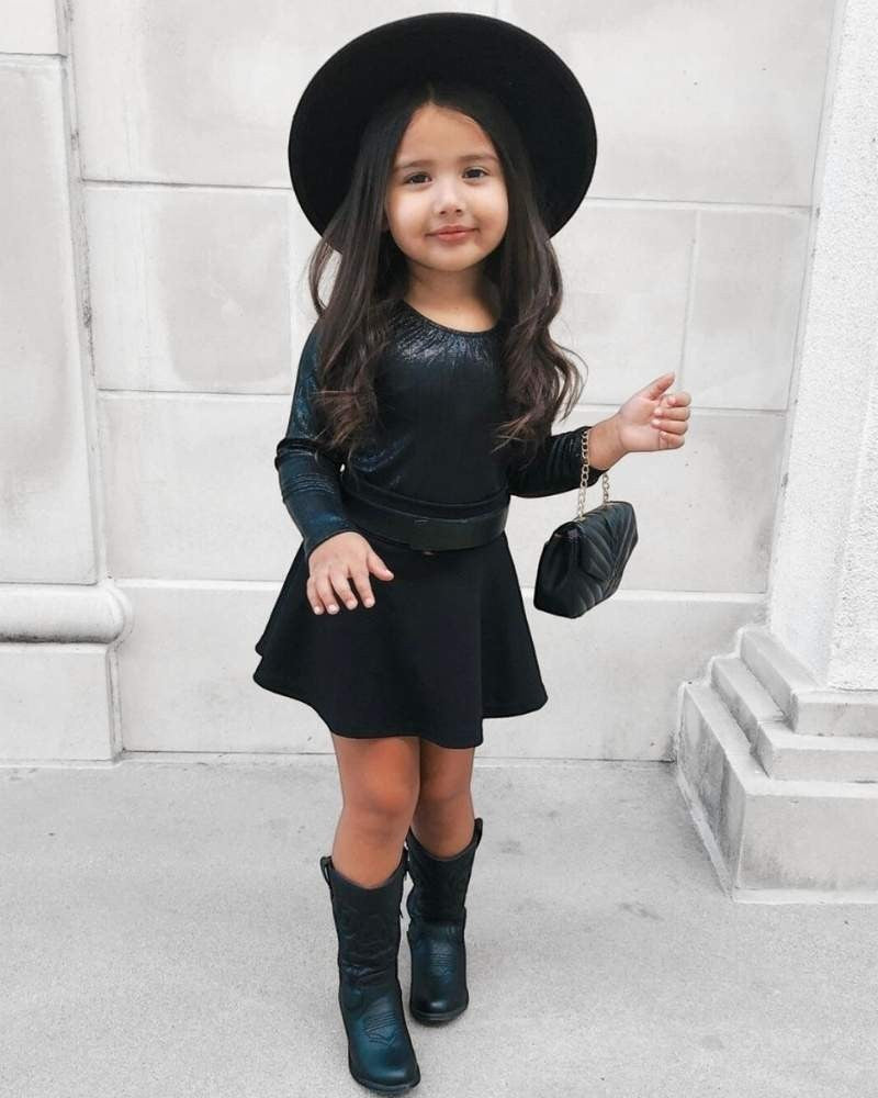 Sea Dragon Dreams girls' shimmering onyx black long sleeve leotard styled with a black skirt, hat, and boots.