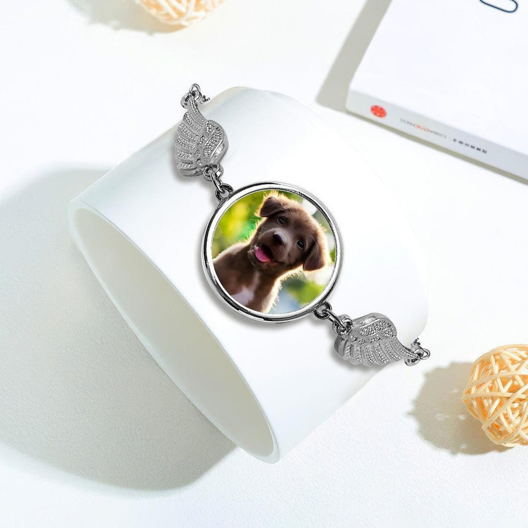 Sea Dragon Dreams silver pet memorial bracelet featuring a circular photo charm flanked by delicate angel wings.