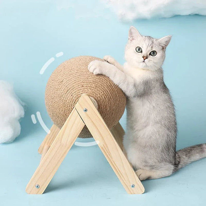 Sea Dragon Dreams cat scratching ball toy with natural sisal rope on a wooden stand, played with by a silver kitten.