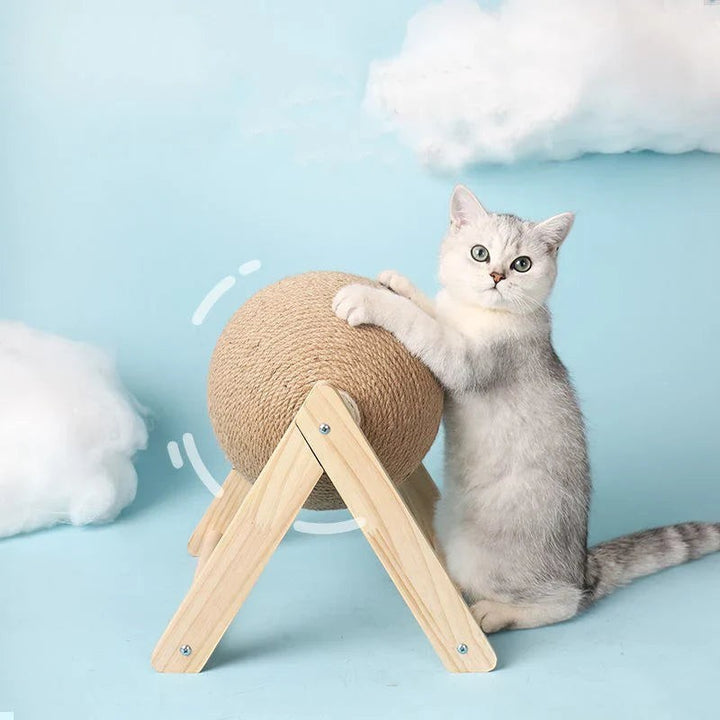Sea Dragon Dreams cat scratching ball toy with natural sisal rope on a wooden stand, played with by a silver kitten.