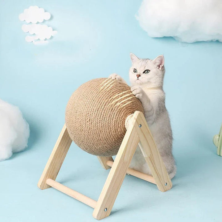 Sea Dragon Dreams cat scratching ball toy with natural sisal rope on a wooden stand, being used by a white kitten.