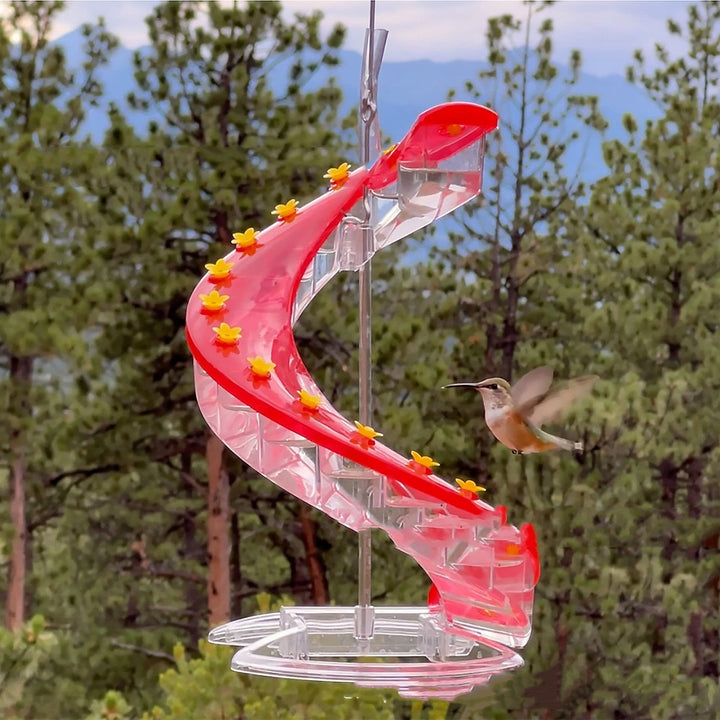 Sea Dragon Dreams spiral hummingbird feeder with red nectar ports and climbing perches in a garden setting