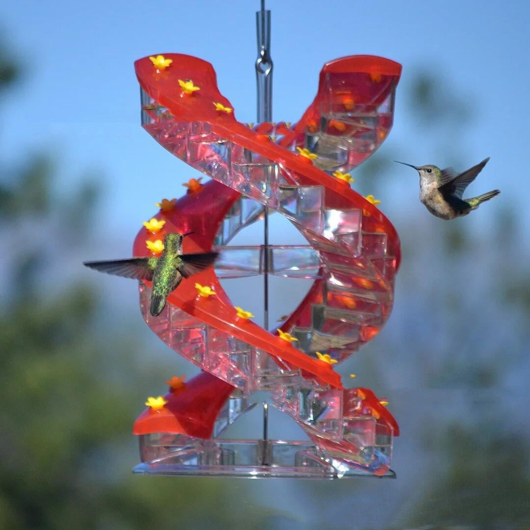 Sea Dragon Dreams red spiral hummingbird feeder with climbing perches and hummingbirds feeding in a garden setting