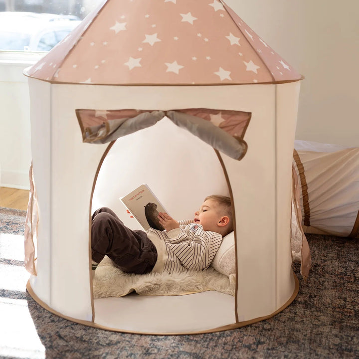 Sea Dragon Dreams 3-in-1 play tent in beige with star patterns, featuring a child reading inside on a soft rug.