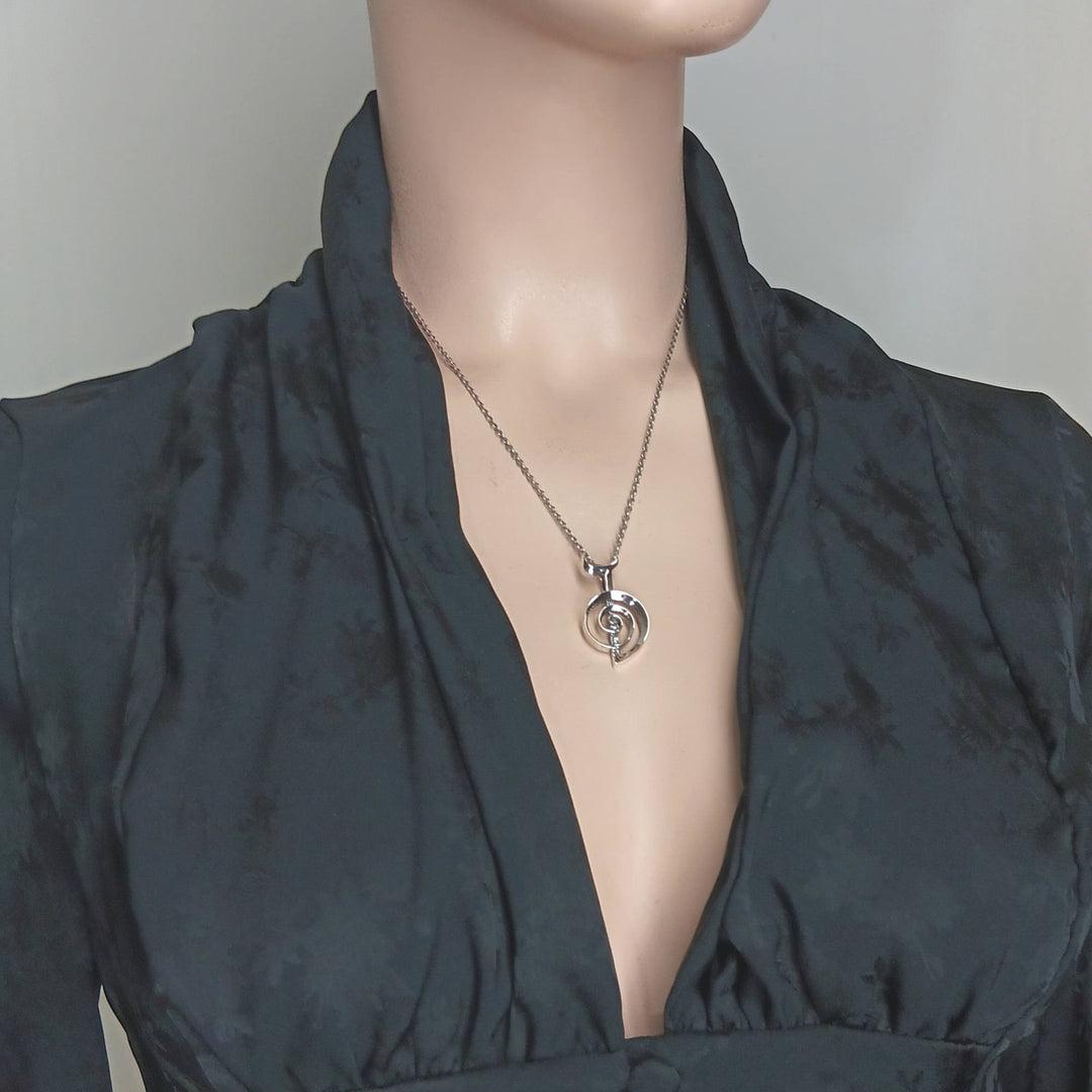 Sea Dragon Dreams handmade sterling silver Cho Ku Rei Reiki pendant necklace worn on a mannequin in a black top