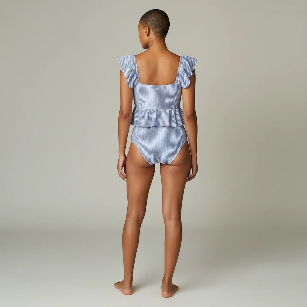 Model wearing a Sea Dragon Dreams blue and white striped slim-fit bikini set with ruffled sleeves, back view.