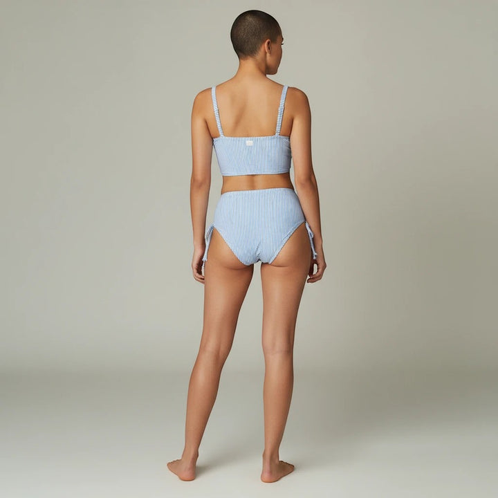 Sea Dragon Dreams blue and white striped two-piece bikini with pleated details, shown from the back on a model.