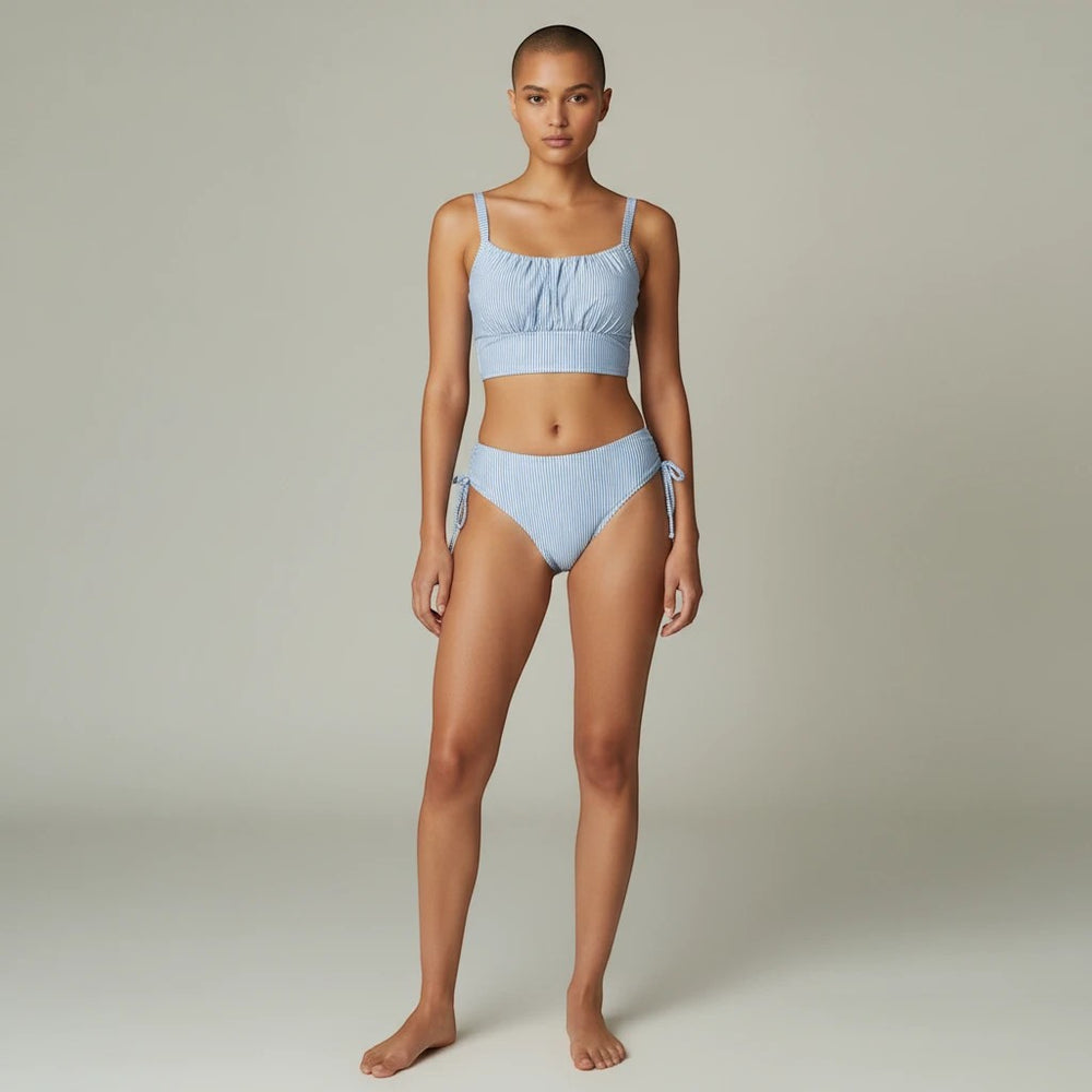 Sea Dragon Dreams light blue striped two-piece bikini with pleated top and tie-side bottoms on a model