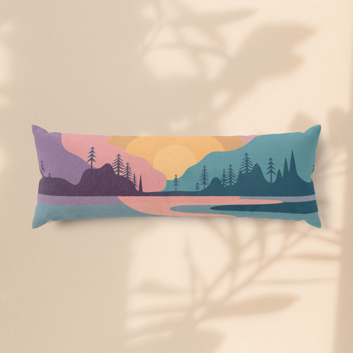 Sea Dragon Dreams sunset mountain landscape body pillow with pine trees and a warm sun on a soft beige background.