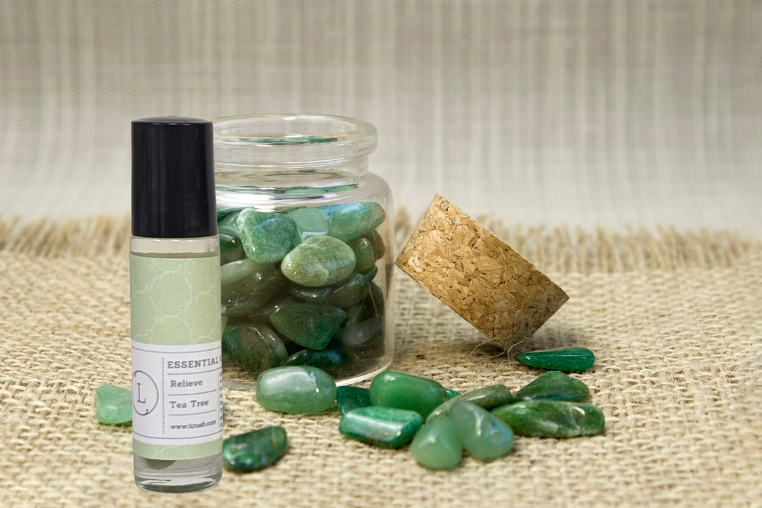 Sea Dragon Dreams tea tree CBD essential oil roll-on with green crystals in a glass jar on a burlap background