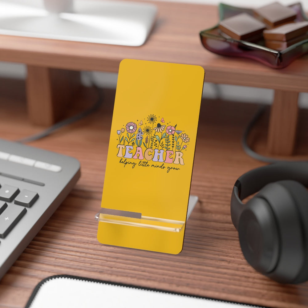 Sea Dragon Dreams yellow hardboard smartphone stand with floral teacher design on a wooden desk with office supplies.