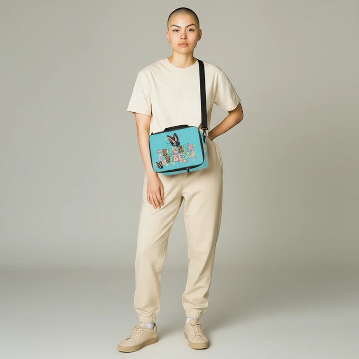 Sea Dragon Dreams Teacher Vibes lunch bag with blue floral design worn crossbody by a model in beige loungewear