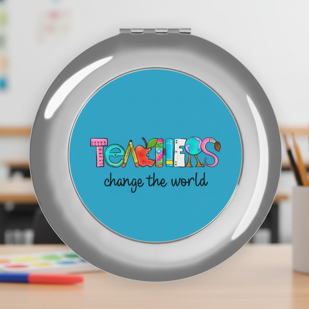 Sea Dragon Dreams round metal compact travel mirror featuring a Teachers Change The World design on a blue background.