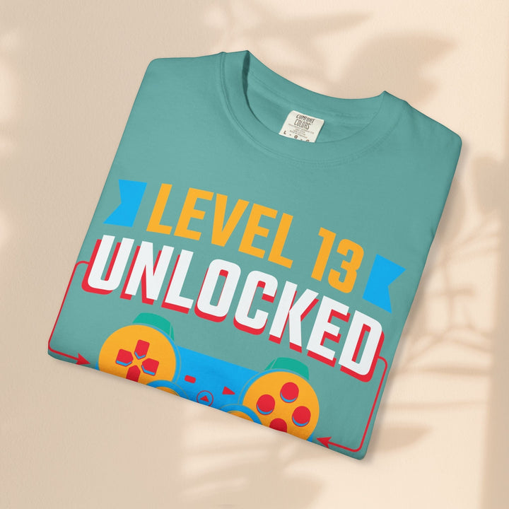 Sea Dragon Dreams Level 13 Unlocked gamer t-shirt in teal cotton with a retro gaming controller graphic print.