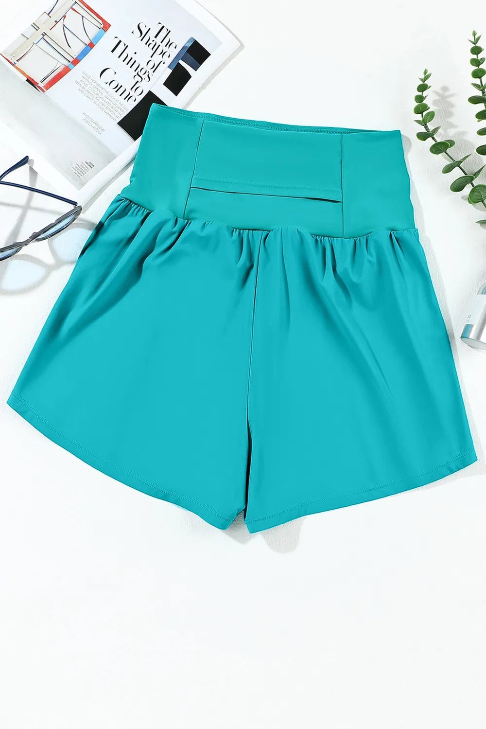 Sea Dragon Dreams high-waisted teal swim shorts with functional side pockets in stretchy polyamide fabric