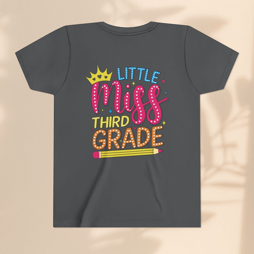 Sea Dragon Dreams youth tee in dark grey cotton with a Little Miss Third Grade graphic featuring a crown and pencil.