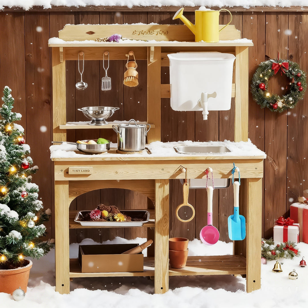 Sea Dragon Dreams Tiny Land Mud Kitchen with water tank, sink, and accessories in a festive snowy outdoor setting.