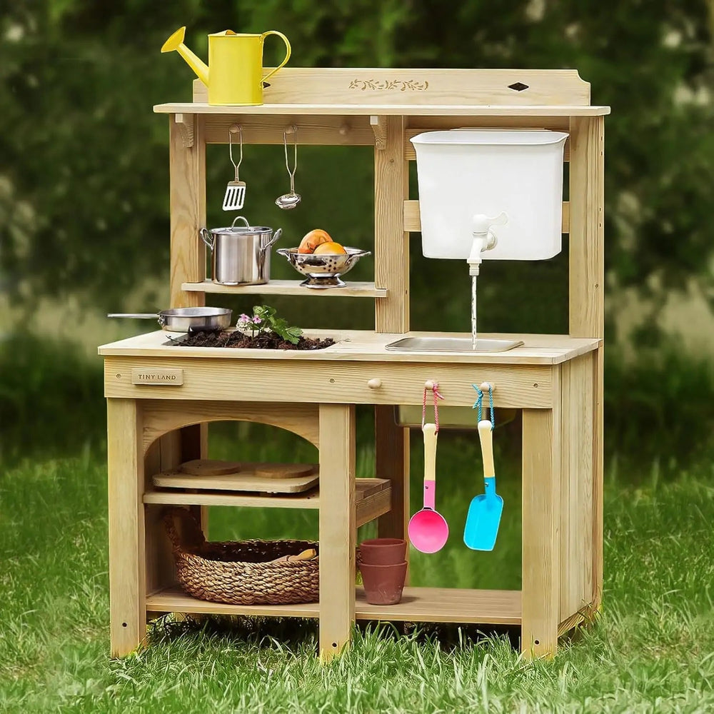 Sea Dragon Dreams Tiny Land wooden mud kitchen with water tank, faucet, sink, and play accessories in a backyard.