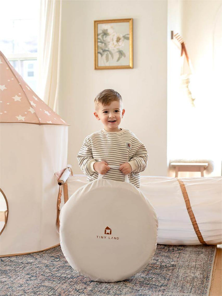 Sea Dragon Dreams Tiny Land 3-in-1 play tunnel set in a beige star-patterned design with a child holding a carry bag.